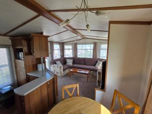 a kitchen and a living room with a couch at Meadow Lakes 71 - Golden Palm Resort - Pet Friendly - On site Swimming Pool - On site club house - Meadow Lakes Caravan Hire in Chapel Saint Leonards