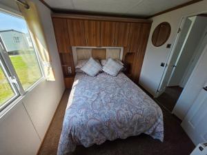 a bedroom with a bed in a small room at Meadow Lakes 71 - Golden Palm Resort - Pet Friendly - On site Swimming Pool - On site club house - Meadow Lakes Caravan Hire in Chapel Saint Leonards