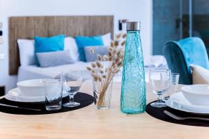 a table with a blue bottle and glasses on it at Bamblue Boutique Apartments in Pineda de Mar