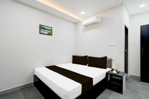 - une chambre blanche avec un lit noir et blanc dans l'établissement Hotel O N Grand, à Hyderabad 21 autres photos