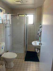 a bathroom with a shower and a toilet and a sink at The Gabba B&B in Brisbane