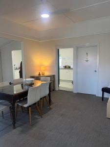 a living room with a table and chairs and a kitchen at The Gabba B&B in Brisbane