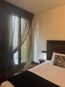 a bedroom with a bed and a window with curtains at Deluxe Oliver's House in Venice