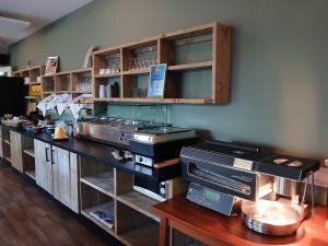 a kitchen with a counter with shelves and a counter top at Drouwenerzand Hotel in Drouwen +21 photos