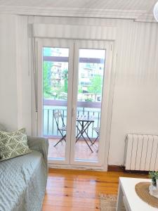 a living room with a couch and a sliding glass door at Habitación turística in Irún +4 photos