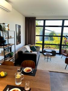 a living room with a couch and a table at Enkhuizer Strand Chalet Wellenreiter Zweite Reihe Haus Nr 213 in Enkhuizen