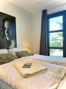 a bed with a towel on it with a window at Enkhuizer Strand Chalet Wellenreiter Zweite Reihe Haus Nr 213 in Enkhuizen