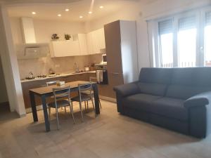 a living room with a couch and a table and a kitchen at Casa Molly in Follonica