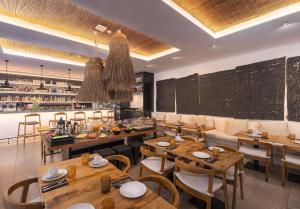a restaurant with wooden tables and chairs and a chalkboard at Hotel Baltum in Albufeira
