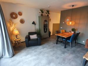 a living room with a dining room table and chairs at Dünenblick am Meer aber 400 meter entfernt, mit renoviertem Badezimmer in Julianadorp