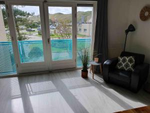 a living room with a chair and a view of a pool at Dünenblick am Meer aber 400 meter entfernt, mit renoviertem Badezimmer in Julianadorp