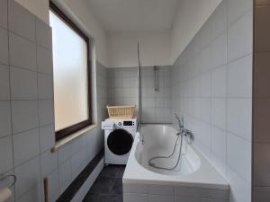 克里米乔Mikra Homes24 in Crimmitschau的带浴缸和洗衣机的浴室