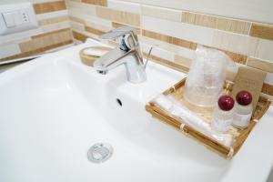 een wastafel in de badkamer met toiletartikelen bij B&B President's Home in Matera