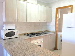 a kitchen with a sink and a microwave on a counter at Apartamentos Arenales Del Sol II in Arenales del Sol