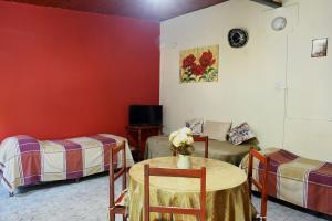 a room with two beds and a table with flowers on it at Rincón Colombiano in Yerba Buena
