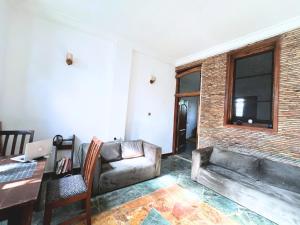 a living room with a couch and a table at Nature's Cradle Garden Lounge in Obosomasi