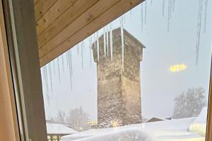 メスティアにあるMestia Mountain Retreatの建物からつららが垂れ下がっている窓