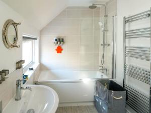 a bathroom with a white tub and a sink at Annedd Wen in Rhosneigr +23 photos