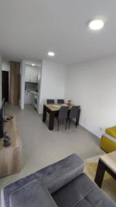 a living room with a couch and a table at Apartman Tri delfina in Rakari +3 photos
