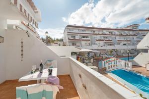 a balcony with a view of a building and a swimming pool at Serene Terrace And Pool in Playa de las Americas