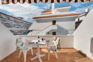 a table and chairs on a balcony with a cruise ship at Serene Terrace And Pool in Playa de las Americas