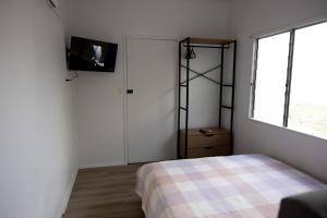 a bedroom with a bed and a tv on a wall at The Little Gem in Clermont