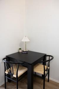 a black table with two chairs and a lamp on top at The Little Gem in Clermont