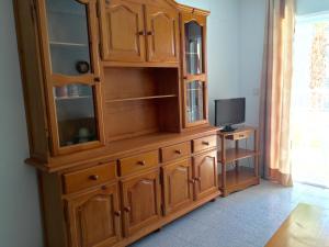 a wooden cabinet with a television in a room at Apartamentos Arenales Del Sol II in Arenales del Sol