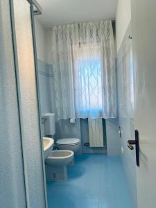 a bathroom with a toilet and a sink and a window at Charming apartment in Porto Azzurro