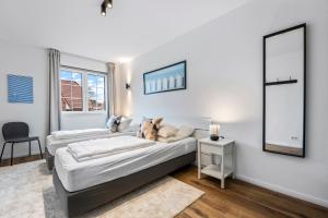 two beds in a room with a table and a chair at Ferienwohnung Stranddüne Rosenhagen bei Travemünde in Dassow