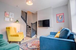 a living room with a blue couch and a yellow chair at Lower Chestnut House, 2 Bedroom, Central Worcester in Worcester