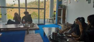 a group of people sitting in a living room at Nirvana Heights Kasar Devi in Hawālbāgh