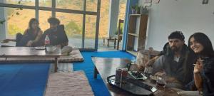 a group of people sitting in a living room at Nirvana Heights Kasar Devi in Hawālbāgh