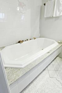 a white bath tub sitting in a bathroom at La Clairière in Guémar