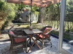 Una mesa y sillas con una sombrilla en un patio. en studio Le Garage, en Bergen