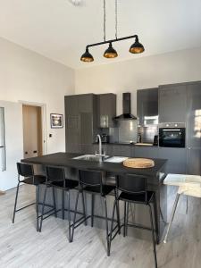 a kitchen with a large black island with black chairs at The Tower Suite - Town Centre, Spacious, 2 Bed, Sleeps 4 in Larne +24 photos