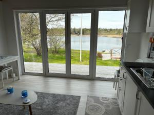 a kitchen with a large sliding glass door at Sjöstuga, lake view cottage in Spersboda