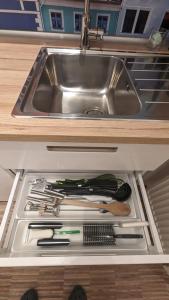 a drawer in a kitchen with a sink and cooking utensils at Meissen Apartments - moderne Ferienwohnungen in Meißen am Lutherplatz in Meißen +30 photos