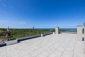 a large patio with a view of the ocean at Modern Apartment Nadmorska in Mrzeżyno with Parking near the Sea by Noclegi Renters in Mrzeżyno