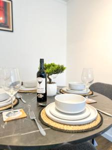 a table with plates and a bottle of wine on it at Folkestone Oasis - Central 2 Bedroom Apartment - Pets Welcome! in Folkestone