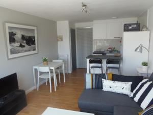 uma sala de estar com um sofá e uma cozinha em Apartment Aloha Sitges em Sitges