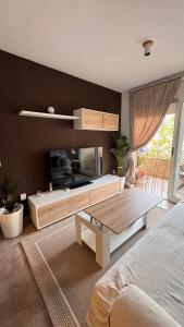 Un dormitorio con una sala de estar con televisión y una mesa. en Apartamento en Canet De Berenguer Playa - Valencia, en Valencia