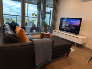 a living room with a couch and a flat screen tv at Rise to the top! in Melbourne