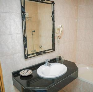 ein Badezimmer mit Waschbecken, Spiegel und Badewanne in der Unterkunft Loft in Kiyovu, Kigali in Kigali + 4 Fotos