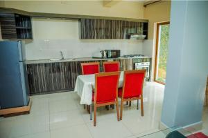 a kitchen with a table and four red chairs at Loft in Kiyovu, Kigali in Kigali