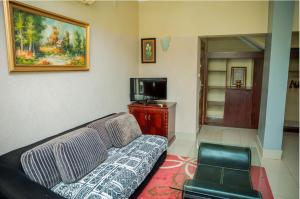 a living room with a couch and a tv at Loft in Kiyovu, Kigali in Kigali