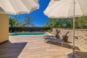 una silla y una sombrilla junto a la piscina en Holiday house AMARILLA with private pool, en Krk