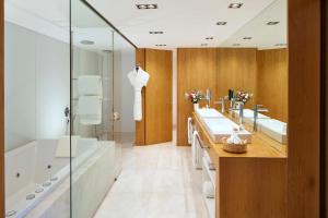 a bathroom with two sinks and a tub and a shower at Victoria Golf Resort and Spa Managed by Accor in Vilamoura