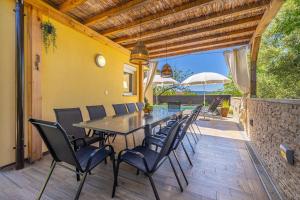 Una mesa de comedor y sillas en un patio. en Holiday house AMARILLA with private pool, en Krk