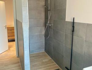 a bathroom with a shower with a glass door at Ferienwohnung Nordwind - Haus Seeschwalbe in Wangerland